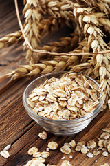 Oatmeal and oatmeal on the wooden background. Healthy eating concept