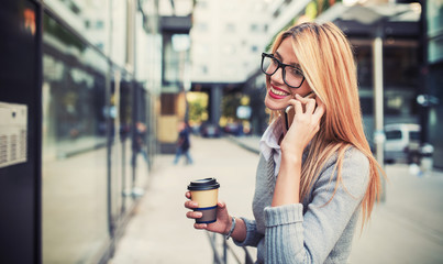 Business woman drinking coffee and talking on a mobile phone outdoor. Business, education,...