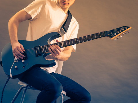 Young man playing electric guitar