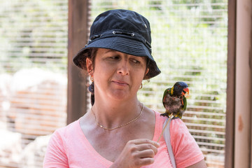 Young  woman feeds parrots at the Australian Zoo Gan Guru in Kibbutz Nir David, in Israel