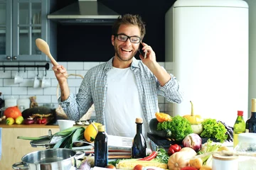 Photo sur Plexiglas Cuisinier Un jeune homme essaie de préparer le dîner à la maison