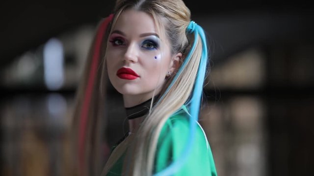 Unusual woman with fantastic makeup and unconventional hairstyle holding baseball-bat