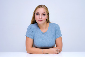 Fototapeta premium Studio portrait of a beautiful blonde girl on a white background in different poses with different emotions