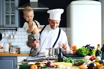Dad and little son are cooking dinner