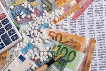 Euro banknotes with pills and calculator on account statement