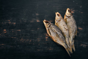 Dried salted fish. Snack for beer. Taranka On a wooden background. Free space for text. Top view.