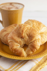 French Croissants Laid Out for Breakfast with a Cinnamon Topped Latte