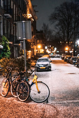 Bicycles parked along the road, night