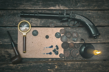 Blank page document, magnifying glass, smoking pipe, musket and money on the detective spy agent table background.