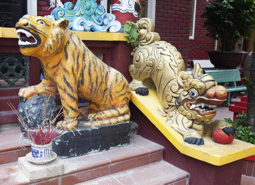 Tiger and lion statues at the entrance of a temple
