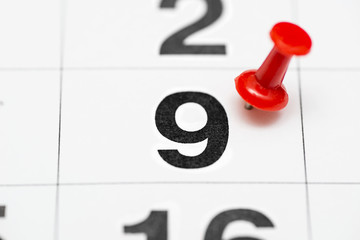 Pin on the date number 9. The ninth day of the month is marked with a red thumbtack. Pin on calendar