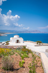 Fototapeta na wymiar Traditional small whitewash Greek Orthodox Chapel on the edge of Aegean sea.