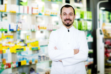 Male pharmacist displaying assortment of drugs