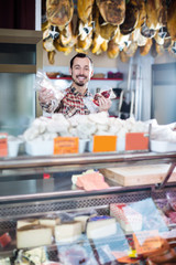 Smiling man seller showing sorts of meat