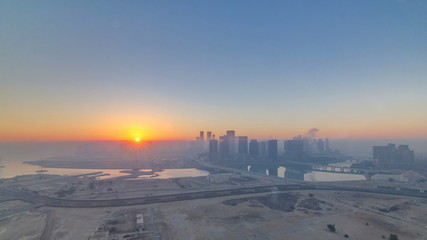 Abu Dhabi city skyline with skyscrapers at sunrise from above timelapse