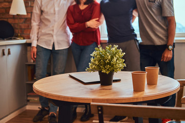 Cropped photo of a group of interracial students with laptop in a student dormitory.