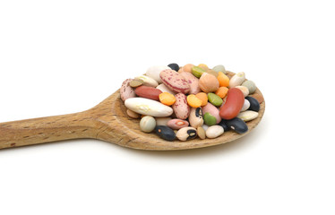 A mixture of legumes in wood spoon on white background.