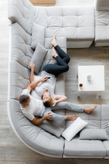 Young couple resting on sofa at home. Family relaxation lifestyle