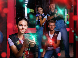 Portrait of young girl took aim colored laser guns during laser