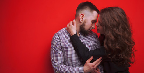 Love, tenderness and relationship concept. Young happy couple against red background