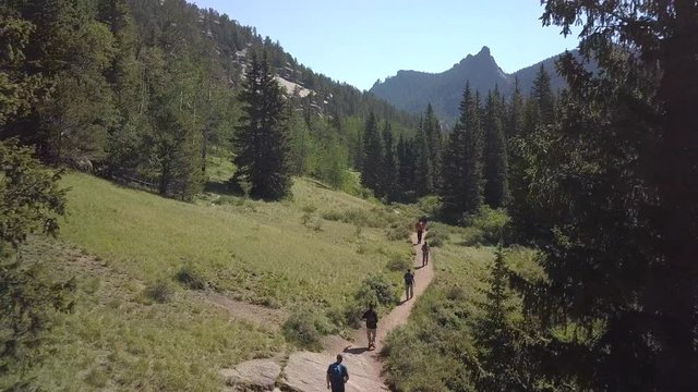 A Groups of Hikers Hiking Along a Trail in a Colorado Valley, Forward Drone Movement