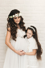 Attractive pregnant mom with her daughter waiting for the baby. Photos of pregnancy in recent weeks