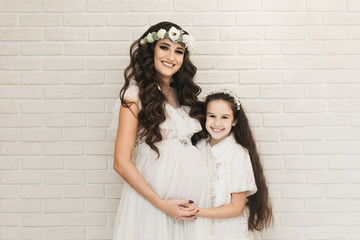 Attractive pregnant mom with her daughter waiting for the baby. Photos of pregnancy in recent weeks