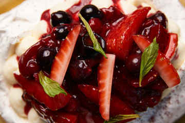 Dessert Pavloca cake with fruits and berry ice cream on wooden table background, close-up