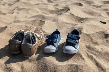 Close up view on abandoned shoes and yellow sand