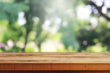 Wooden table and blurred green garden background.