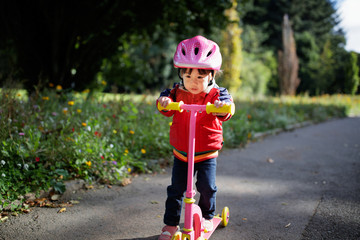 baby girl play scooter in forest park © M-image