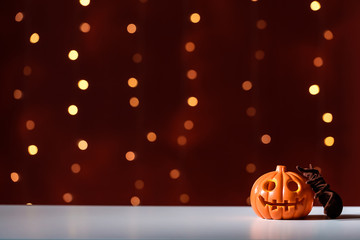 Halloween pumpkin with spider on a shiny light dark red background