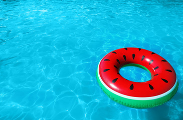 Inflatable ring floating in swimming pool on sunny day. Space for text