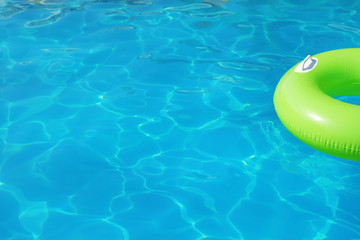Inflatable ring floating in swimming pool on sunny day. Space for text