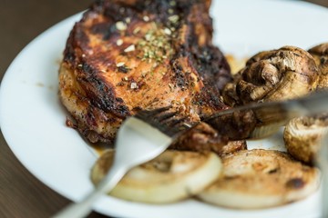 Grilled Steak, Mushrooms and Onion on the Plate with Cutlery -