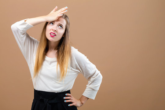 Young woman making a mistake on a brown background