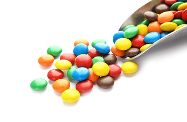 Scoop and colorful candies on white background