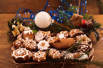 Homemade cookies for Christmas, decorated with sugar glaze, laid in a glass dish.