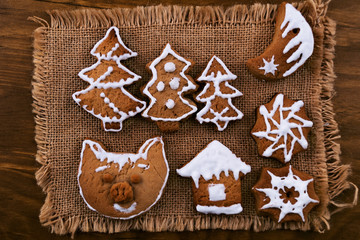 Cookies made to decorate the Christmas table, with sugar glaze, on a linen napkin, wooden background.