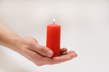 Red candle in loving hands