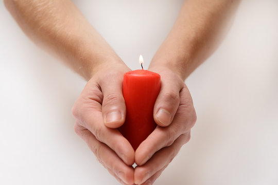 Red candle in hands - Powered by Adobe