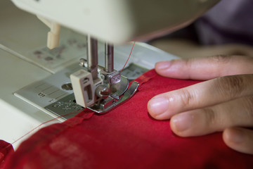 Woman seamstress working making clothes on a sewing machine.