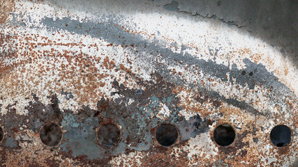 Rusty metal surface with several holes