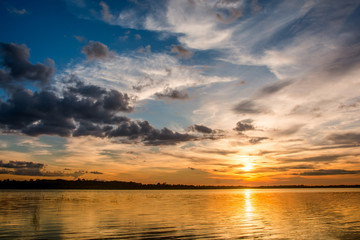 Sunset in the lake. beautiful sunset behind the clouds above the over lake landscape background. dramatic sky with cloud at sunset