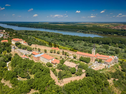 Aerial summer panorama of ruined Ilok castle on the Croatian Serbian border above the Danube river in Croatia with blue sky