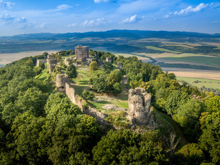 Fototapeta na wymiar Aerial panorama of ruined medieval Saris castle in Slovakia with round towers, donjon, walls, and blue sky background