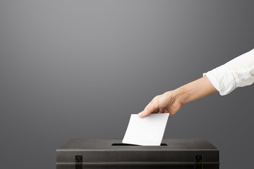 Hand holding ballot paper for election vote at place election background. Election vote concept.
