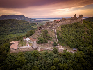 Aerial sunset panorama of ruined medieval Szigliget castle in Hungary above the Lake Balaton with orange yellow sky