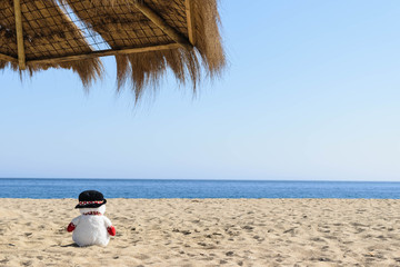 Snowman at the beach. On vacation concept