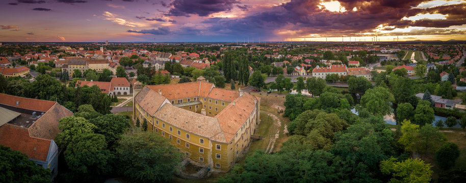 Stunning sunset with purple red blue orange and yellow colors over Mosonmagyarovar roman catholic church and castle in Hungary